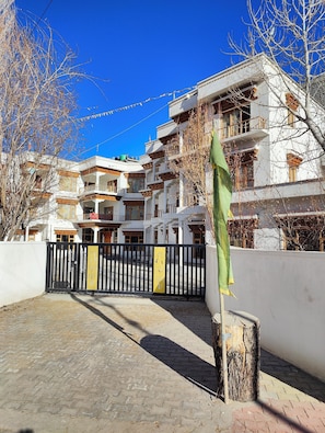 Un edificio a più piani con uno stile architettonico tradizionale, caratterizzato da balconi e un ingresso con cancello.