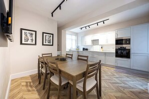 Eine moderne Küche mit weißen Schränken, einem eingebauten Backofen und einer Mikrowelle.