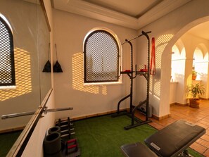 A gym with exercise equipment, a bench, and a window with a lattice design. - Front Line Golf Luxury | Private Retreat & Course Views (Banos y Mendigo)