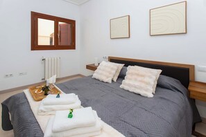 A bedroom with a bed, pillows, a bedside table, a window, and artwork on the wall. - Front Line Golf Luxury | Private Retreat & Course Views (Banos y Mendigo)