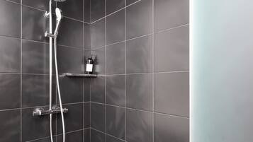 Une douche moderne dotée d’un pommeau de douche à main et d’un panneau de commande fixé au mur.