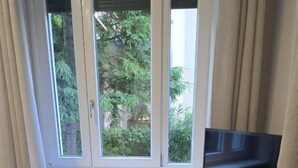 A room with a window, radiator, and a flat-screen TV on a stand. - Bergamoinluxe (Bergamo)