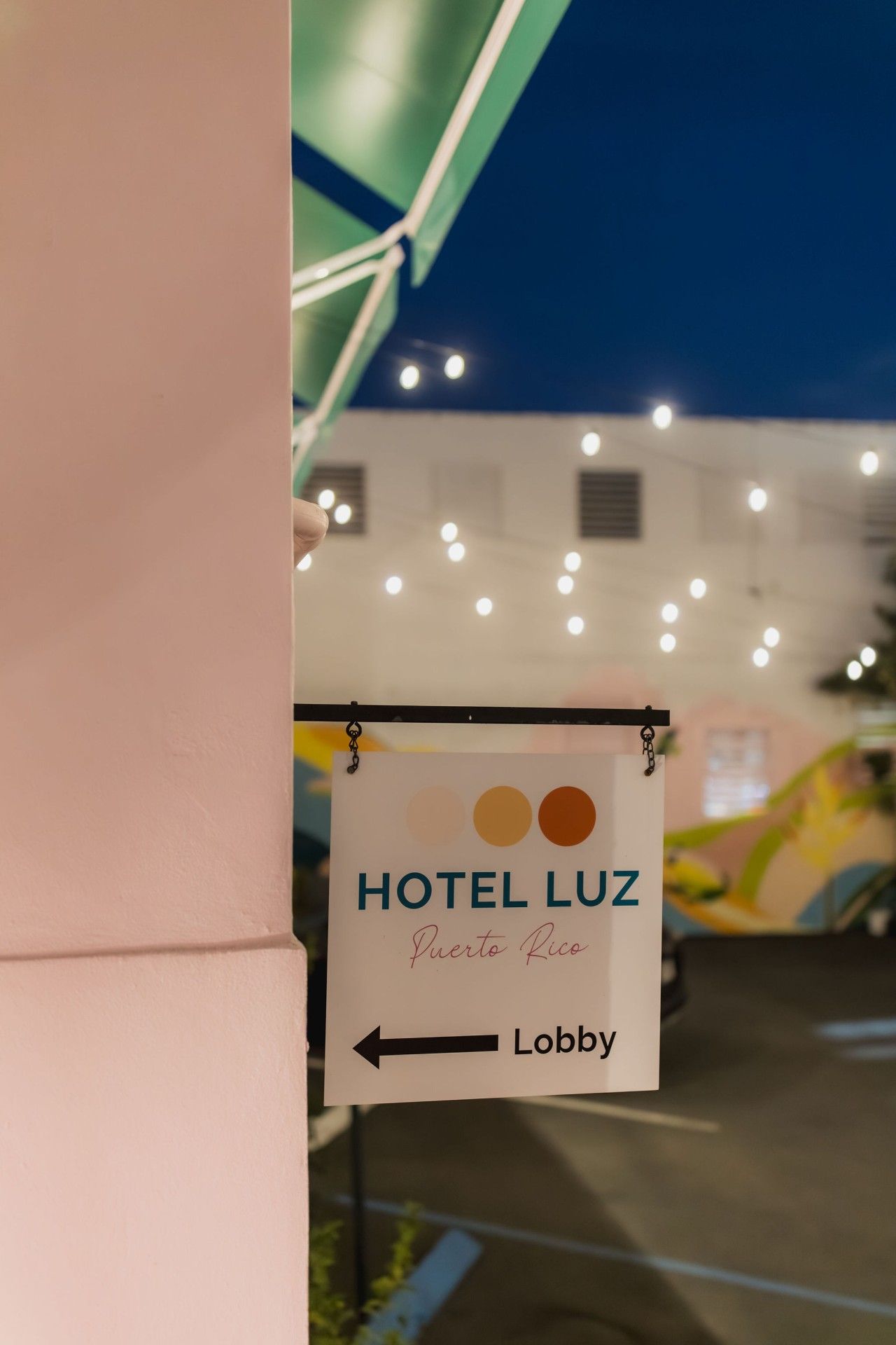 Señalización para 'HOTEL LUZ Puerto Rico' con una flecha que indica la recepción.