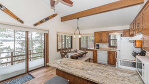 A spacious kitchen with a large island, wooden cabinets, and a view of the outdoors.