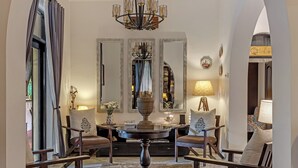 A formal dining area with a round table, chairs, and a chandelier. - Casa de Tartaruga - Heritage Goan Estate - Private Pool, Tropical Garden, Staff (North Goa)
