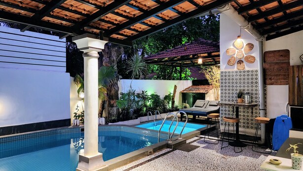 A private pool area with a tiled deck, lounge chairs, and a covered pergola. - Casa de Tartaruga - Heritage Goan Estate - Private Pool, Tropical Garden, Staff (North Goa)