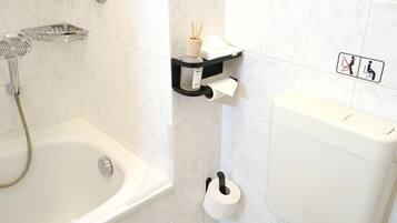 Un baño con bañera, inodoro y ducha.