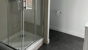 A glass-enclosed shower with a handheld showerhead and a wall-mounted faucet. - Renovated studio with wifi-center of town and beach on foot (Cabourg)