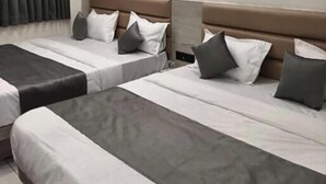 A hotel room with two beds, a ceiling fan, and a large window with curtains. - Hotel 7 CR (Ahmedabad)