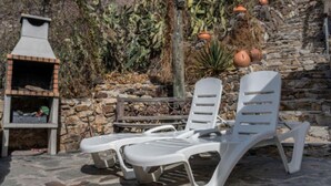 A stone wall, a barbecue grill, and two white lounge chairs. - Casa Rural Pepita - Gran Canaria Center - Tejeda (Pagos de Casas Juan Gómez)