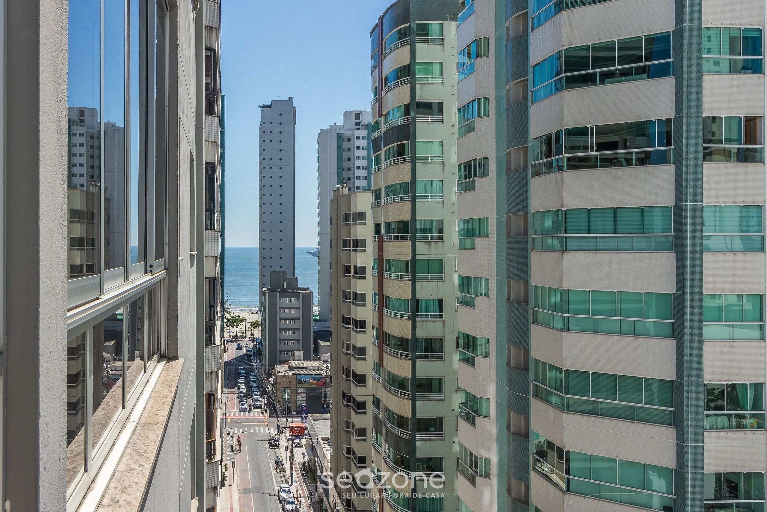Un edificio de gran altura con numerosos pisos, ventanas amplias y vista al mar.