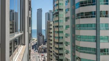Um edifício alto com vários andares, janelas amplas e vista para o mar.