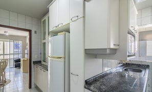 A kitchen with white cabinets, a refrigerator, and a granite countertop. - Apt in Downtown BC 350m From the Beach Pae1002 (Balneário Camboriú)