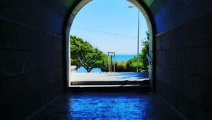Un tunnel en arc qui mène à un point de vue donnant sur une étendue d’eau et une végétation luxuriante.