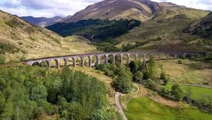 A viaduct in a hilly landscape with lush greenery and distant mountains. - A Spacious 3-Bedroom Retreat at the Gateway to the Highlands (Inverlochy)