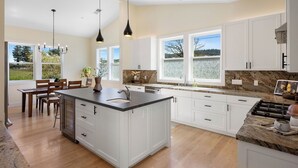 A spacious kitchen with a large island, white cabinetry, and a granite countertop. - Beautiful & dog-friendly vacation retreat in the heart of Sonoma Country (Santa Rosa)