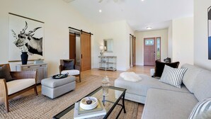 A spacious living room with a sofa, armchairs, a coffee table, and a large painting. - Beautiful & dog-friendly vacation retreat in the heart of Sonoma Country (Santa Rosa)