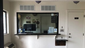 A reception area with a counter, a door labeled "Employees Only," and a sign indicating Wi-Fi availability. - Sierra Inn South El Monte. (South El Monte)