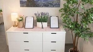 Un comptoir d’accueil orné d’un tableau représentant un ciel nocturne, d’une décoration en forme de cœur et d’une plante en pot.