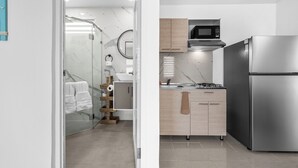A modern kitchen with a stainless steel refrigerator, a microwave, and a gas stove. - 63 Bay View by Otium (Catano)