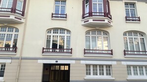 Un edificio de varios pisos con ventanales salientes y acceso directo desde la planta baja.