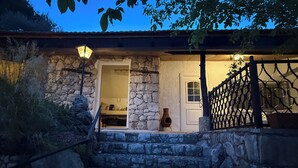 A stone staircase leading to a rustic building with a wooden door and a lantern. - Apartments Benzia (Marina)