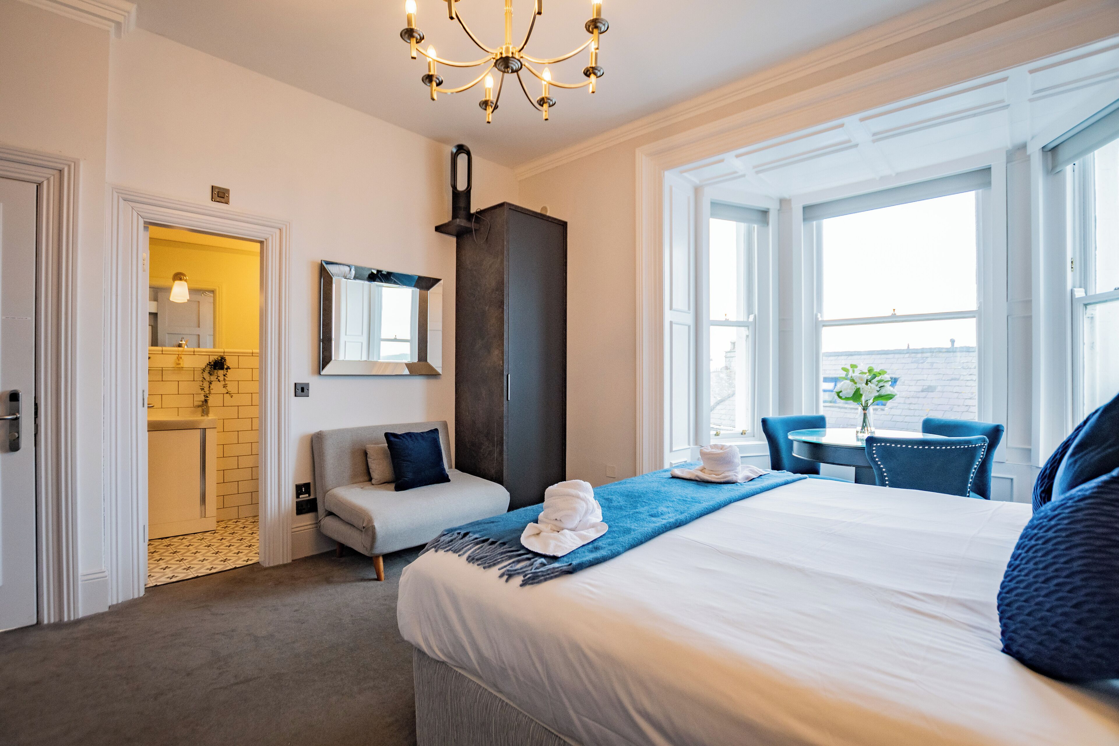 Hotelkamer met een bed, een bureau, een stoel, een badkamer en uitzicht op zee.