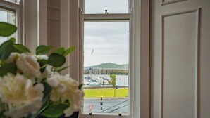 A view through a window with a traffic sign, a body of water, and boats.
