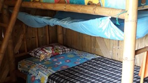 A bunk bed with a colorful quilt and a patterned bedspread. - KingFisher Ecolodge (Misahualli)