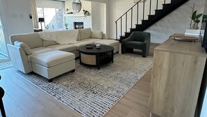 Una sala de estar moderna con un sofá, una mesa de centro y una escalera.