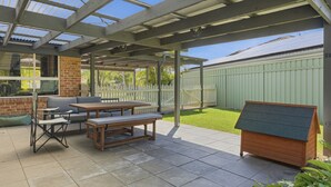 A covered patio with a table and chairs, a bench, and a small wooden structure. - Boater's Retreat - pet friendly, right off the M1 (Boambee East)