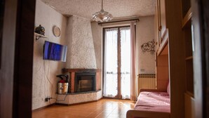 Una habitació amb una llar de foc, televisió i llit.