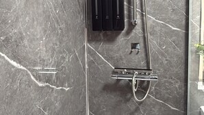 A modern shower with a handheld showerhead, a wall-mounted control panel, and a handheld shower attachment. - Stylish Stay Near Gateacre – South Liverpool (Liverpool)