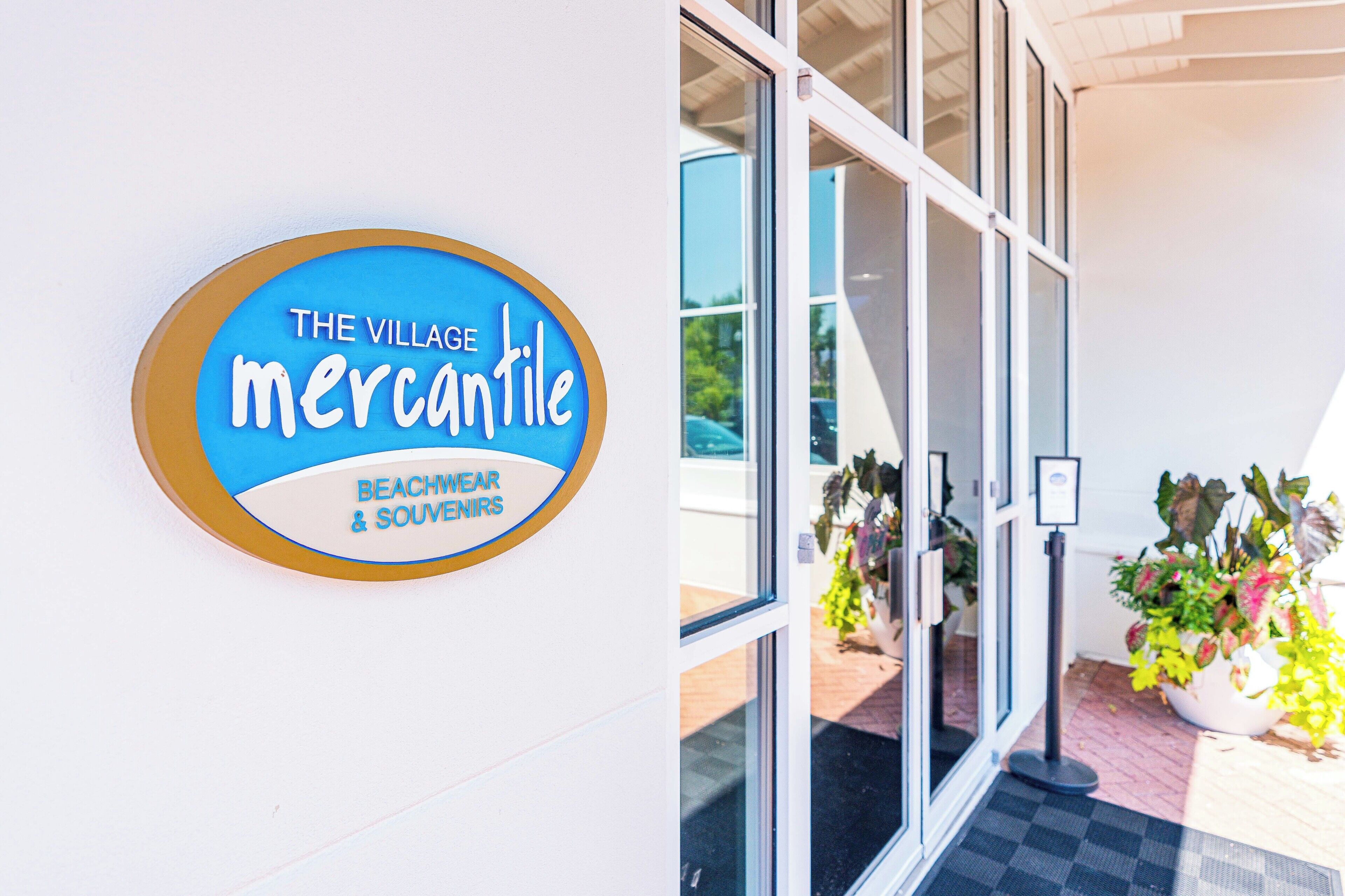 Une enseigne indiquant « The Village Mercantile », avec une entrée bien visible menant à un bâtiment.