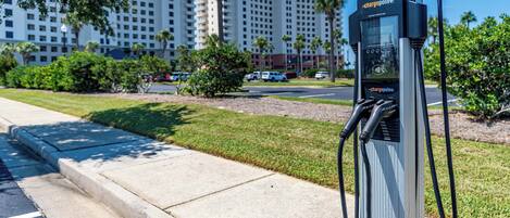 Una estación de carga identificada como 'chargepoint+' con vista despejada a un edificio de hotel de varios pisos.