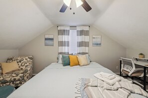 A bedroom with a bed, a chair, a desk, and a ceiling fan. - Spacious & well designed 3br/1.5ba w/ Fiber Wi-Fi! (Toledo)