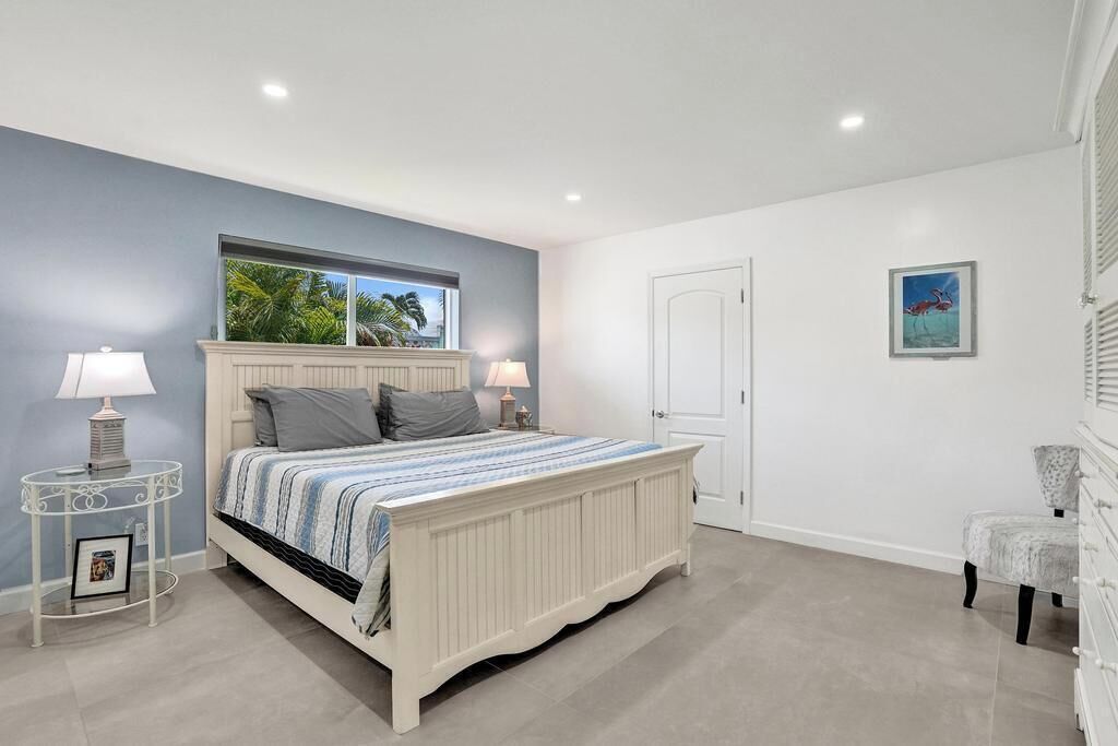 A bedroom with a bed, bedside tables, a chair, and a door.