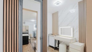 Ein modernes Schlafzimmer mit Schminktisch, Bett und Schreibtisch.
