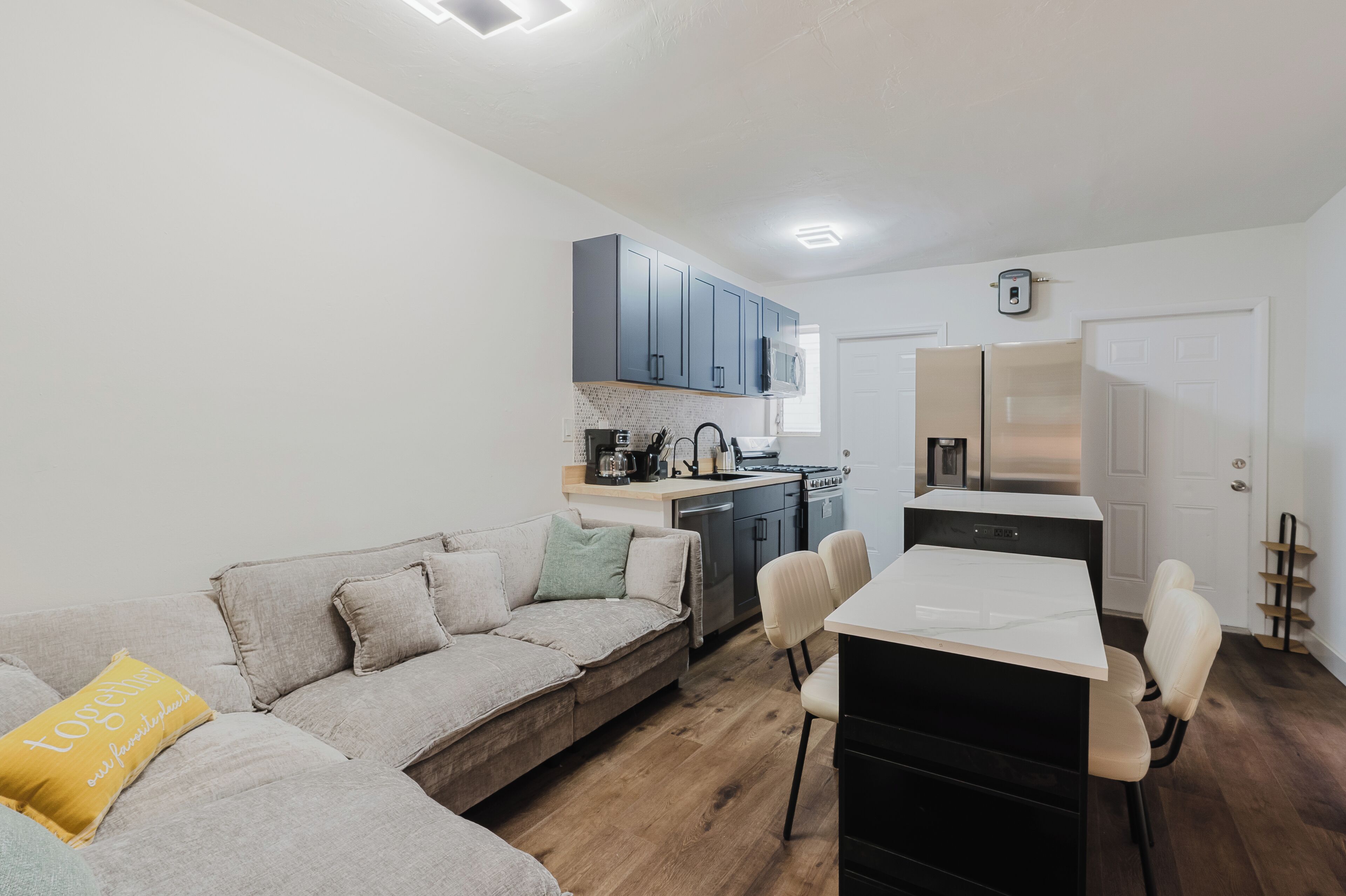 A compact living space with a kitchenette, a sofa, and a dining table.