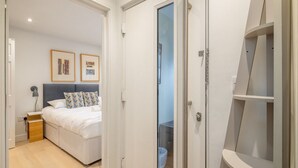 Una camera da letto con un letto, un comodino e una porta che conduce al bagno.