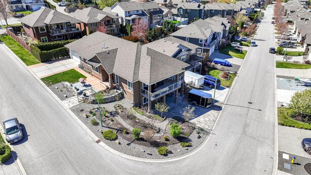 A residential area with houses, a driveway, and a street. - Modern 2BR Walk-Out Suite | 2 Baths | Free Parking (Kelowna)