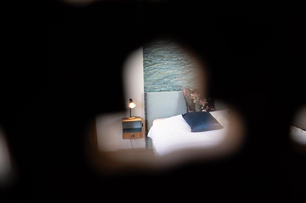 Ein Schlafzimmer mit einem Bett, einem Nachttisch und einer Lampe.