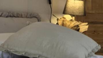 A bed with a white pillow and a wooden headboard.