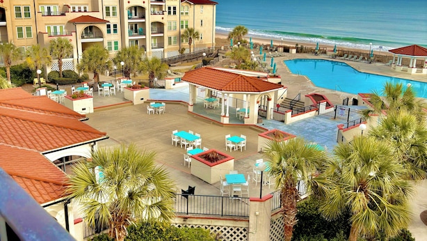 Un hôtel doté d’une piscine, d’un espace extérieur aménagé et offrant une vue sur la plage.
