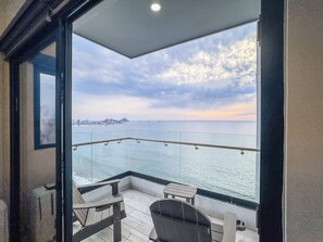 A balcony with a view of the sea and a distant cityscape. - Condo Premium - Malecón | Vista al mar | Grupos 6+ (Mazatlán)
