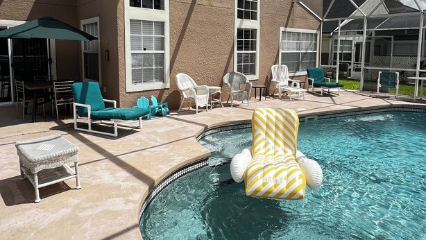 Ein Poolbereich mit Liegestühlen, einem Whirlpool und einer überdachten Terrasse.
