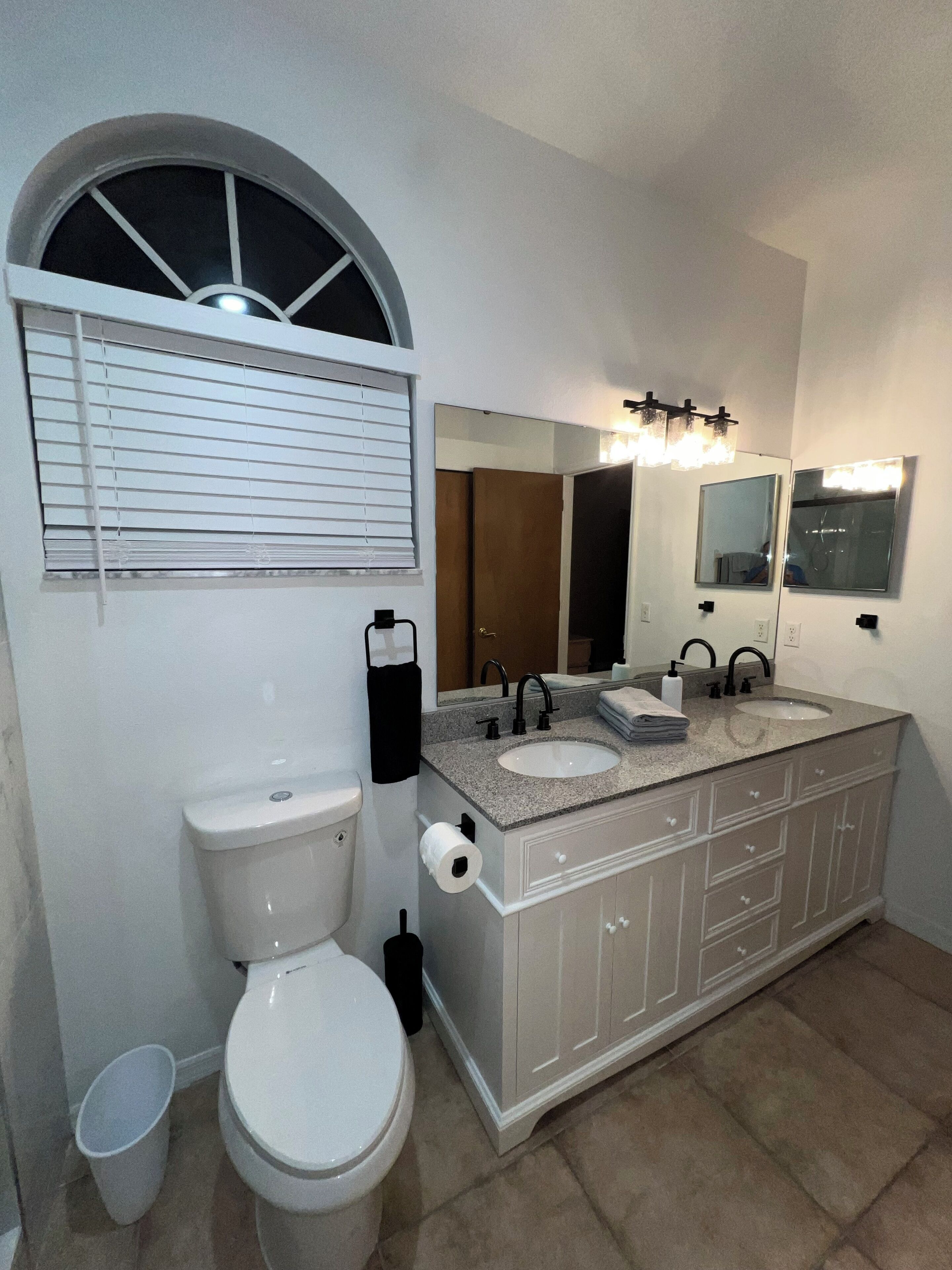 A bathroom with a toilet, bidet, and a double sink vanity.
