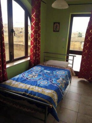 A room with a bed, a window, and a door.