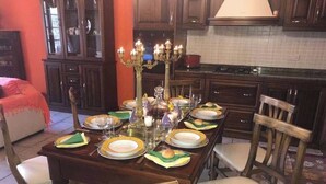 Una mesa de comedor dispuesta con platos, vasos y un candelabro.