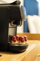 Una cafetera con cuatro cápsulas de café sobre su base.